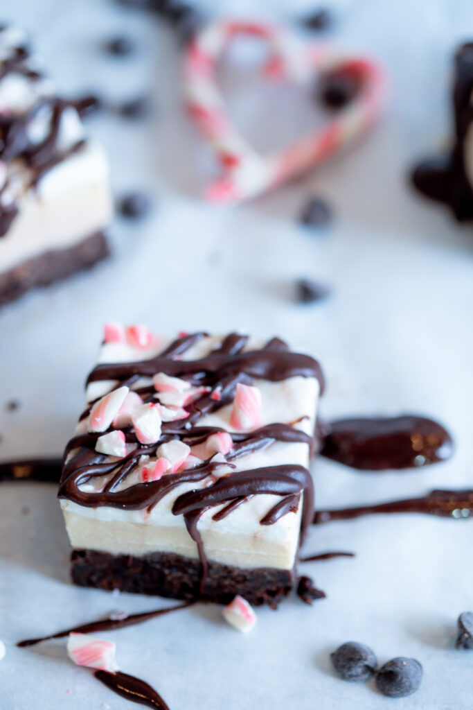 Peppermint Ice Cream Cake topped with crushed peppermints and a chocolate drizzle