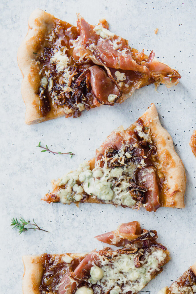 Up close look of Gorgonzola Fig Flatbread cut into triangles on a marble countertop