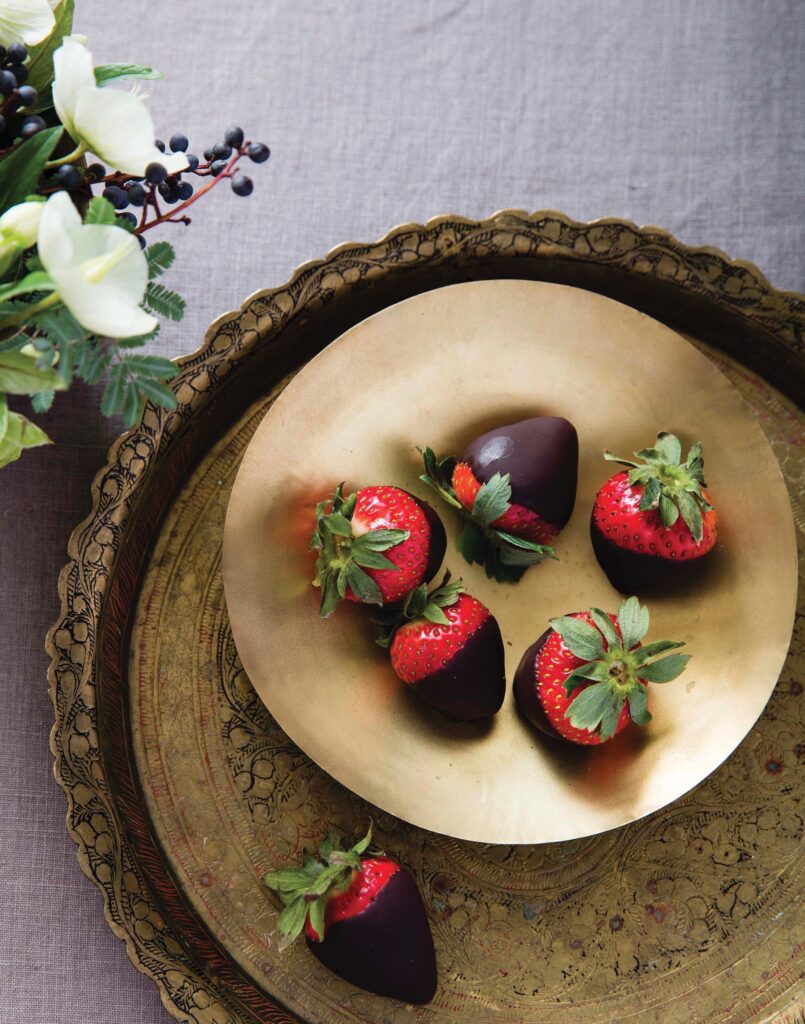 Chocolate Champagne dipped strawberries served on a gold dish 