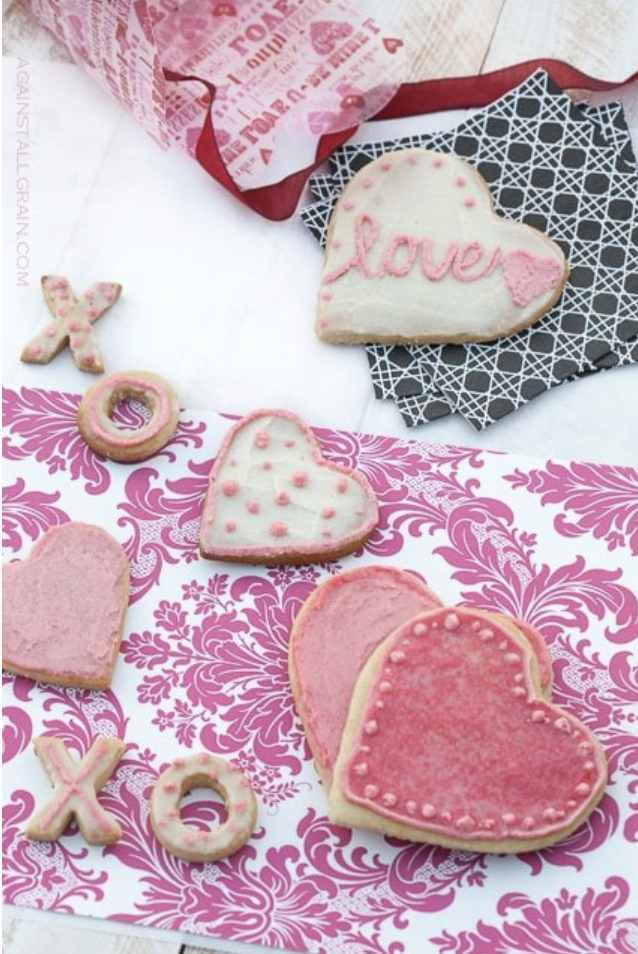 Variety of Valentine's Day themed gluten-free sugar cookies with white, red and pink icing