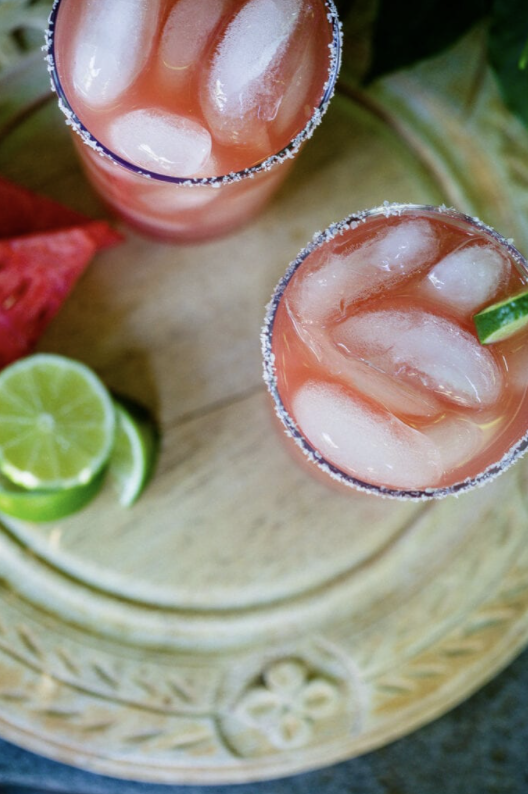 Watermelon Margaritas served in a glass over ice with lime garnishes 