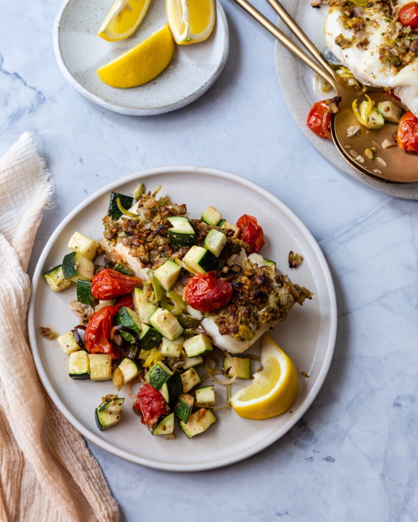 Lemon-Herb crusted halibut served on a white plate with roasted vegetables 