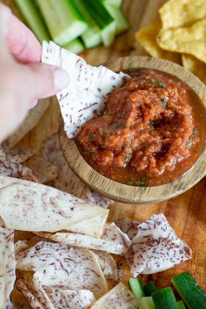 grain free chip being dipped into paleo restaurant style salsa