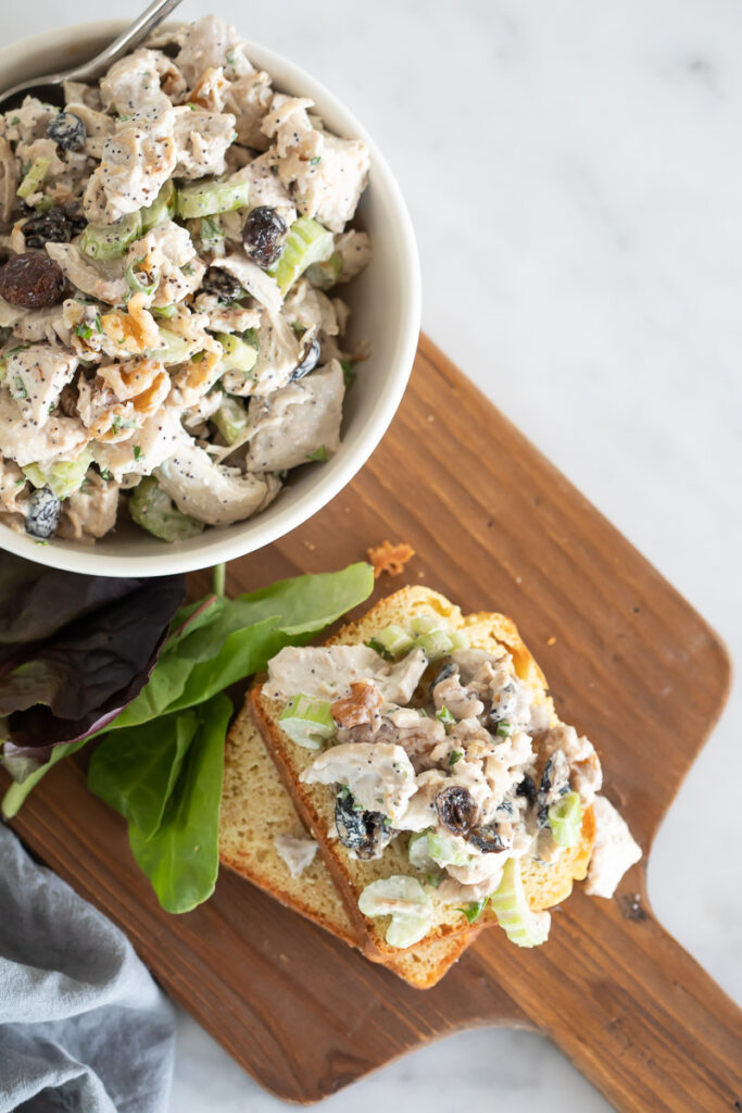 Leftover Turkey Salad in a white bowl and on a grain free slice of bread on a wooden cutting board