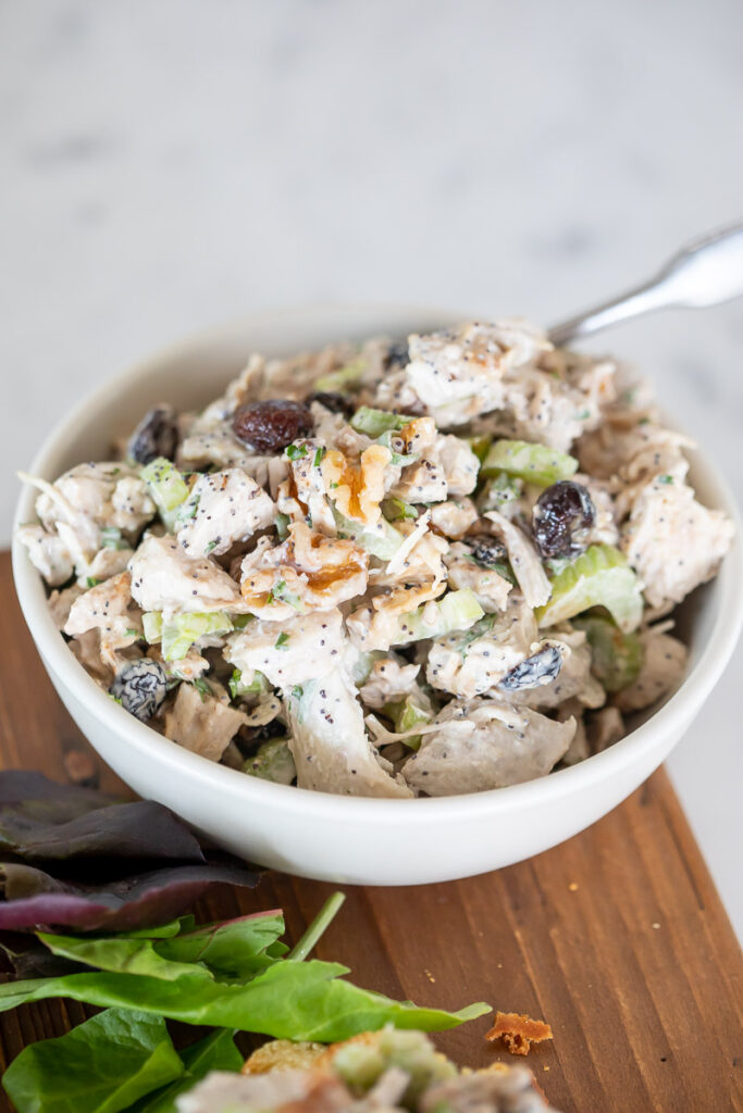 Leftover Turkey Salad in a white bowl on a wooden cutting board