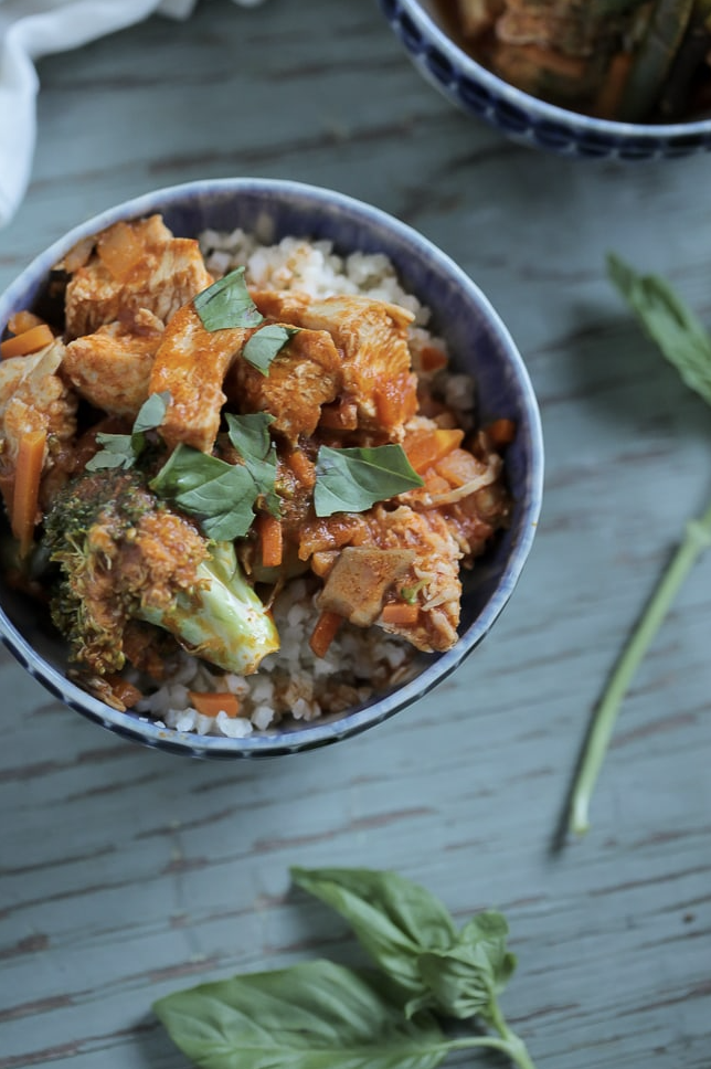 Whole30 Recipes like Danielle Walker's Thai Chicken Stew is pictured in a blue bowl, served over cauliflower rice. 