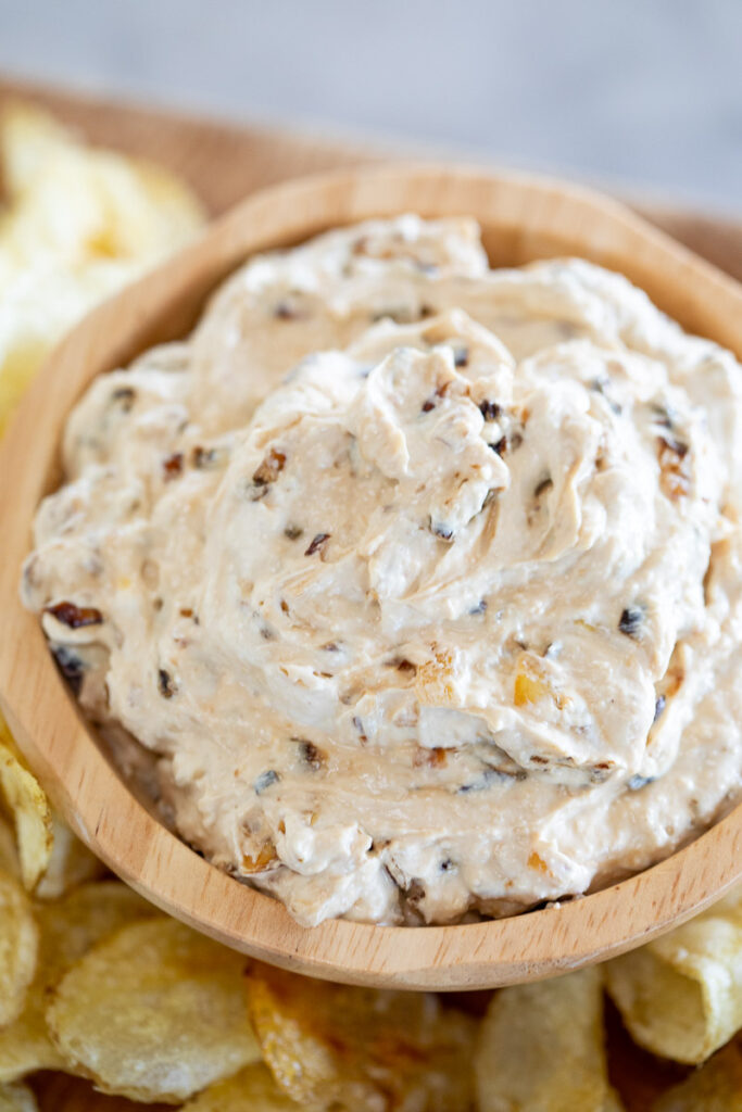 dairy-free creamy onion dip served in a wooden bowl, surrounded by potato chips