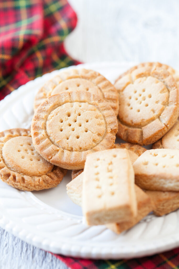 Gluten-free shortbread cookies are pictured on a white plate as part of a collection featuring gluten-free cookie recipes