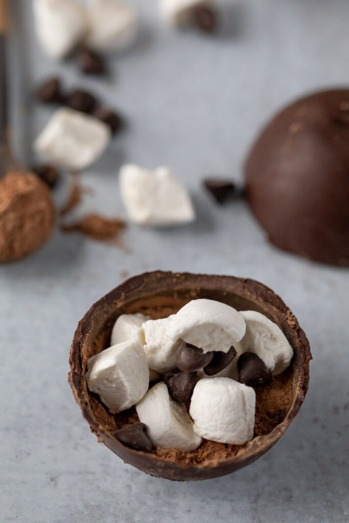 A Dairy-Free Hot cocoa bomb cut in half, displaying marshmallows and chocolate chips