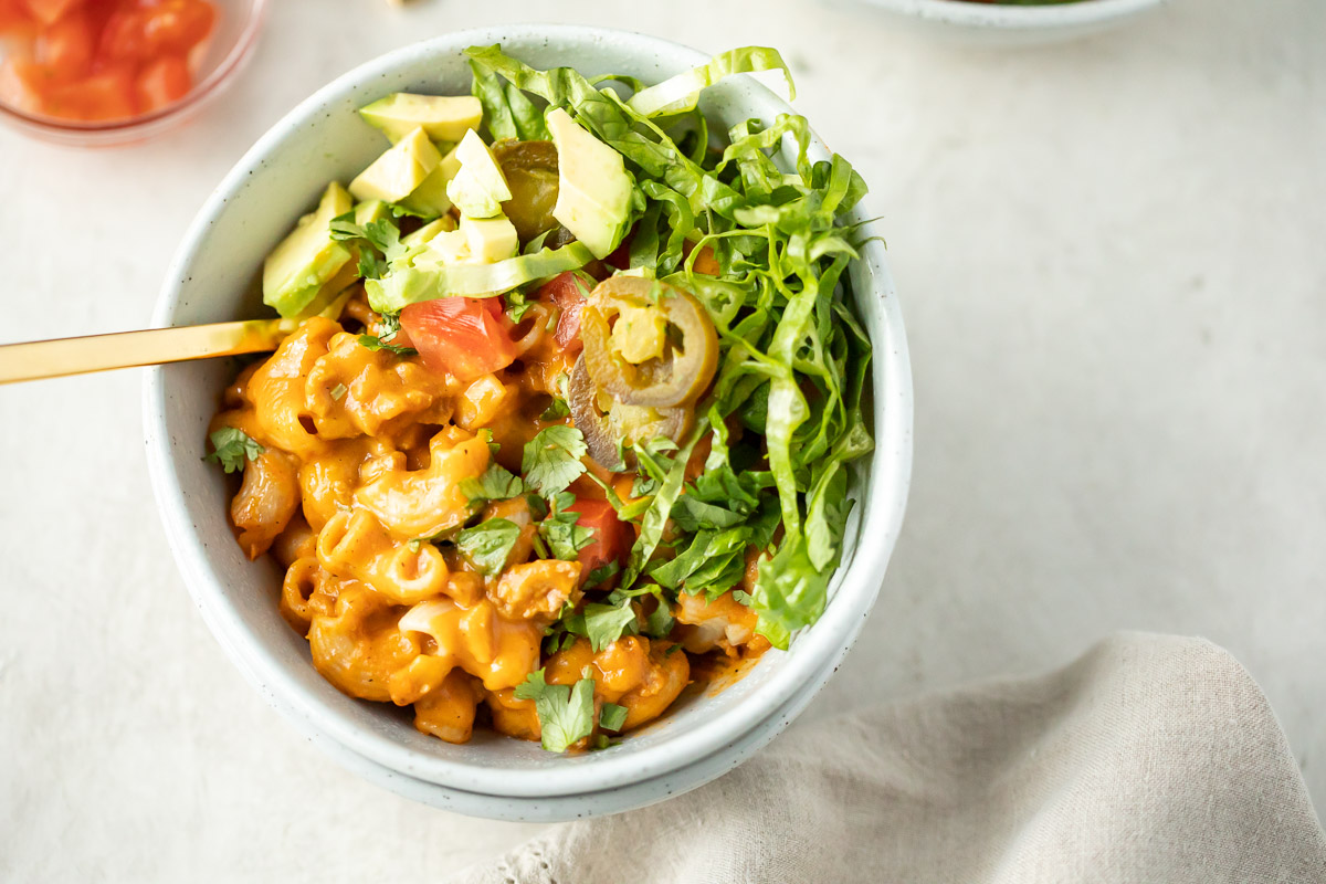 close up image of instant pot taco pasta in a bowl with toppings