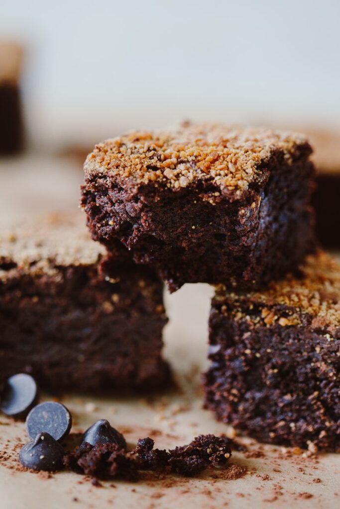 image of three almond flour cinnamon chocolate fudge brownies stacked up with a bite out of one