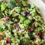 image of broccoli crunch salad with bacon in a white bowl on a countertop