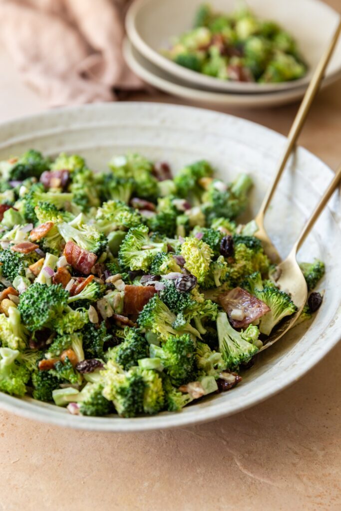 image of broccoli crunch salad with bacon in a white bowl on a countertop