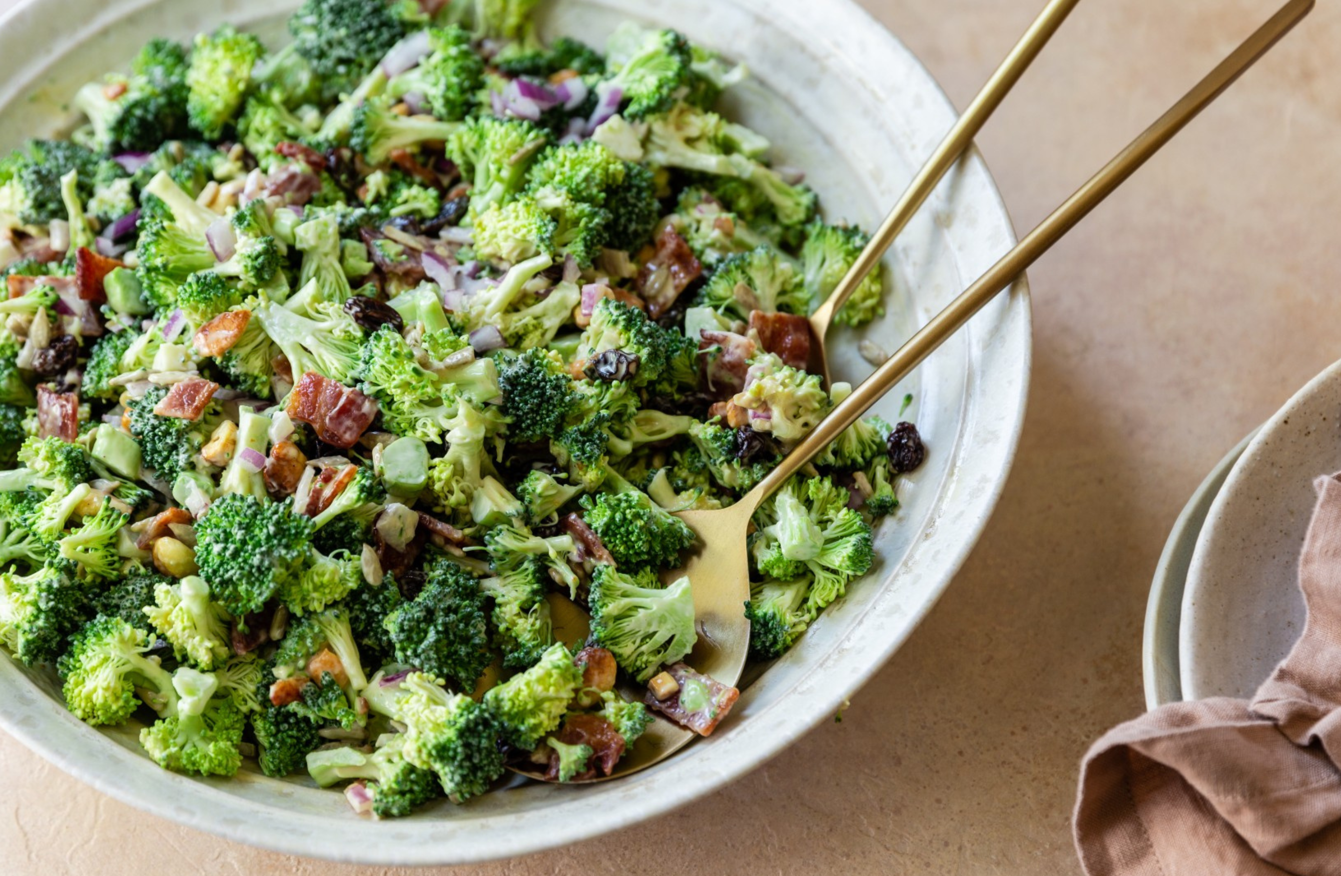 image of broccoli crunch salad with bacon in a white bowl with spoons