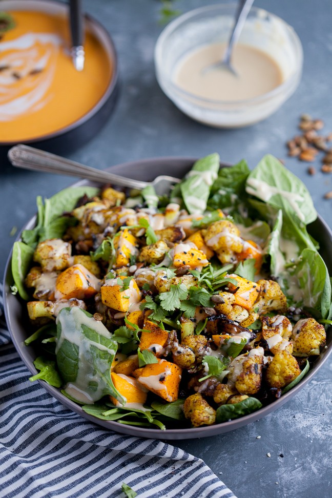 image of cauliflower mango salad in a bowl on a table with a blue table cloth