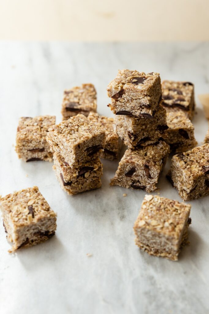 image of gluten free heavenly hunks oat and chocolate chip bites cut into squares on a counter.