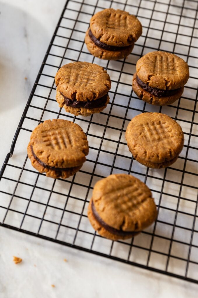image of gluten-free peanut butter fudge cookies on a baking rack on a counter