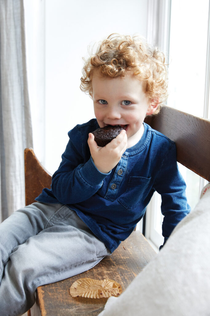 image of a boy eating a chocolate zucchini veggie muffin