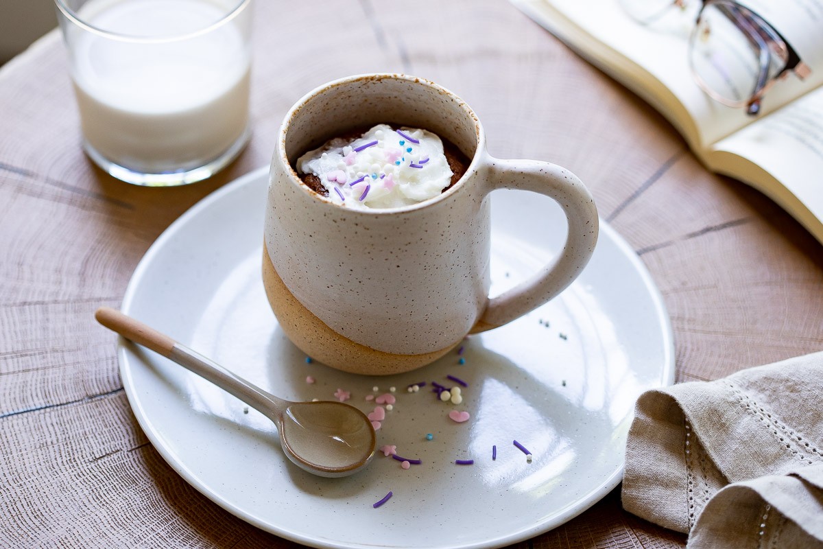 image of chocolate gluten free mug cake on a plate with a spoon