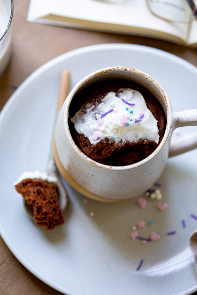 image of a chocolate gluten free mug cake with a bite in the spoon