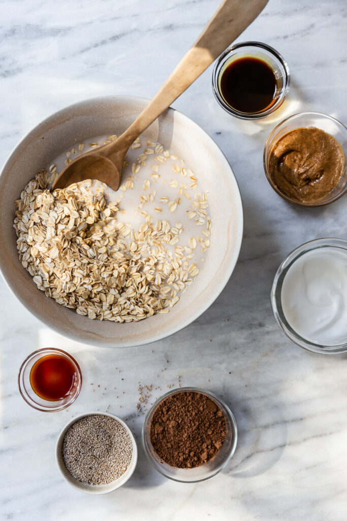 image of ingredients for chocolate protein overnight oats on a counter top in bowls