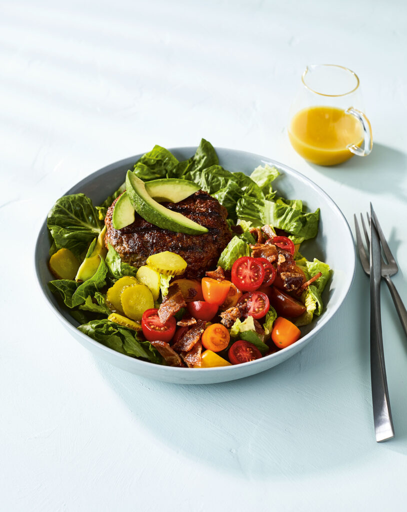 image of a bbq bacon burger bowl on a counter with knife and fork