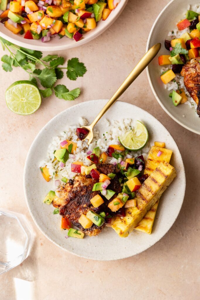 image of grilled bbq chicken thighs with coconut rice and stone fruit salsa and grilled pineapple