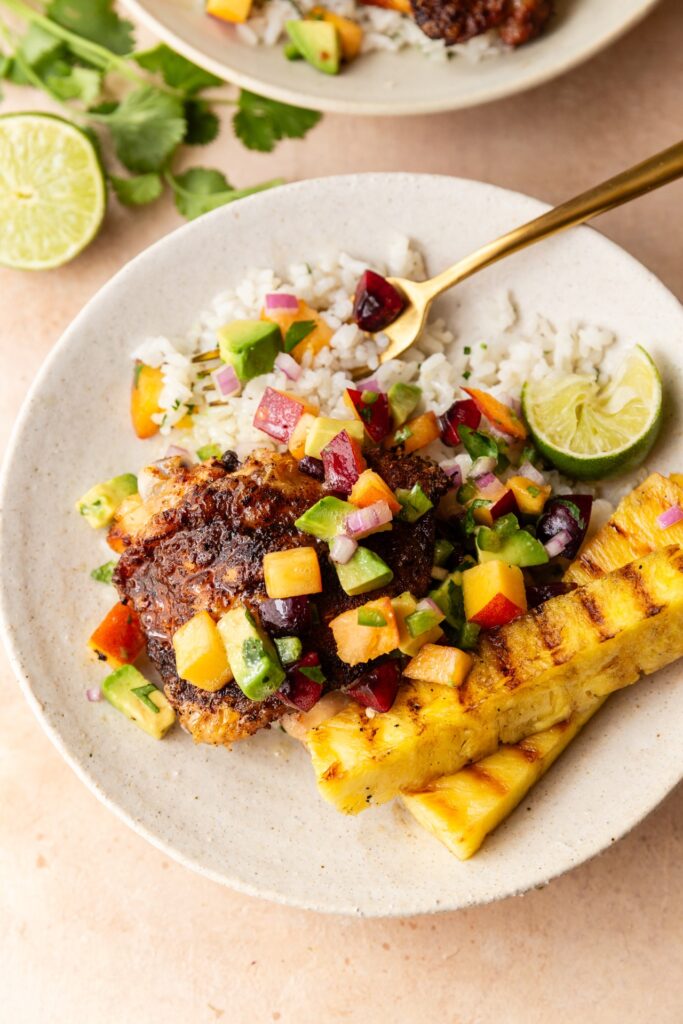 image of grilled bbq chicken thighs with coconut rice and stone fruit salsa and grilled pineapple