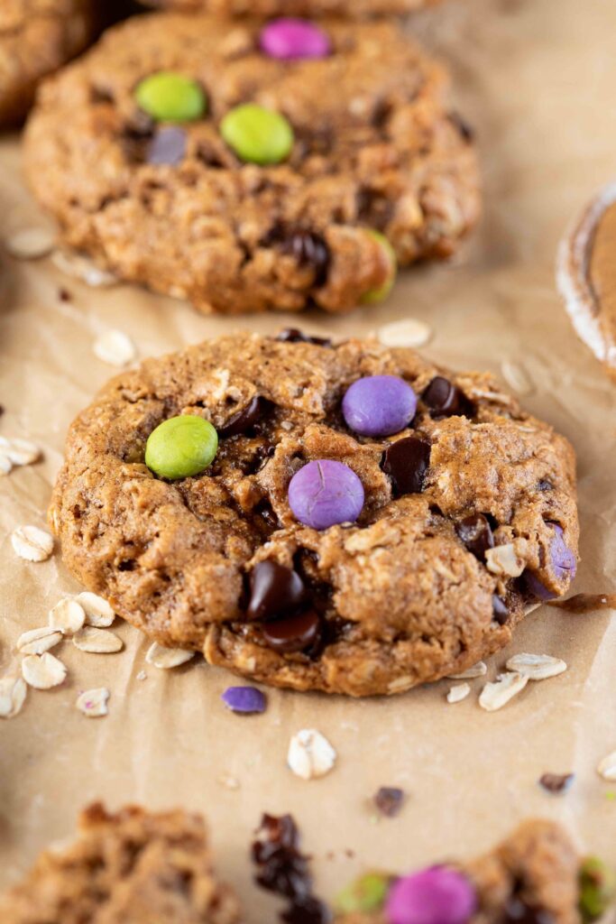 close up of image of gluten-free monster cookies with dye free candies in a piece of parchment paper