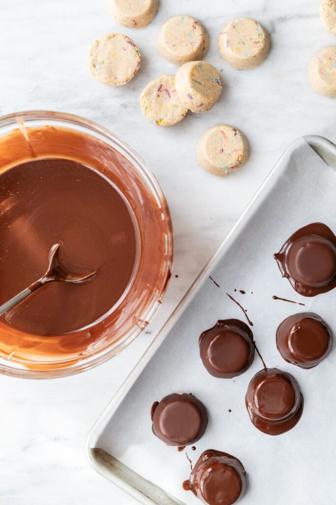 image of chocolate protein balls and chocolate sauce in a bowl on the counter