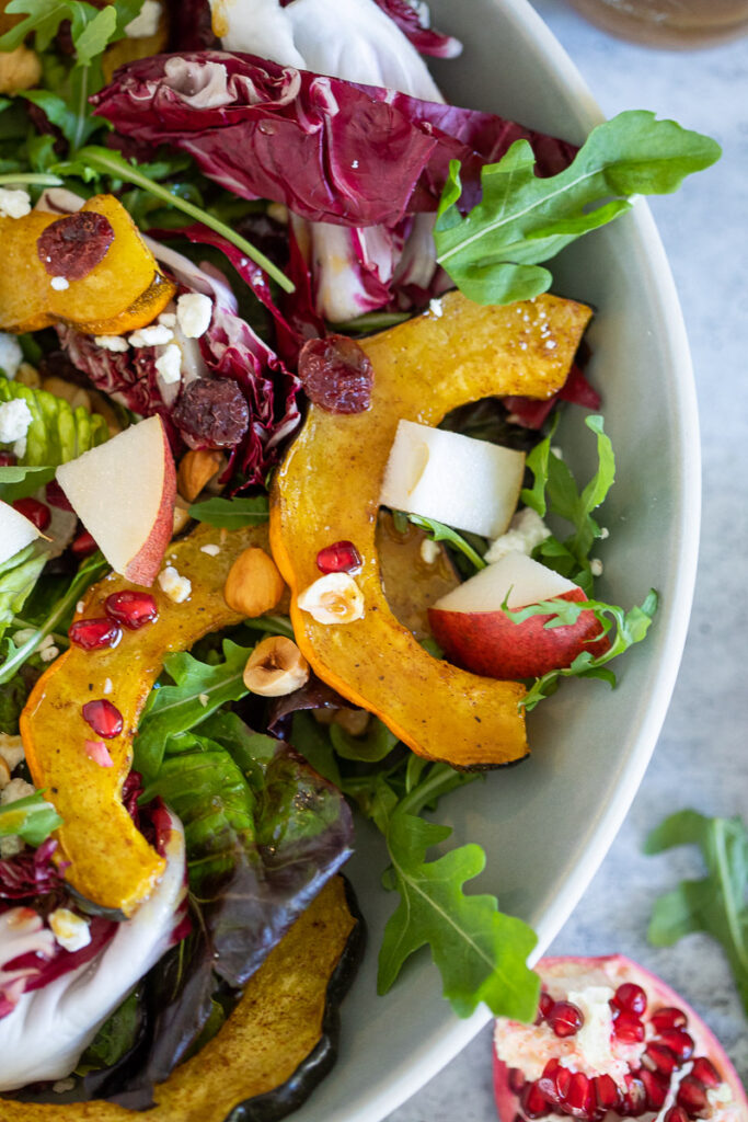 roasted acorn squash salad in large white bowl on white counter