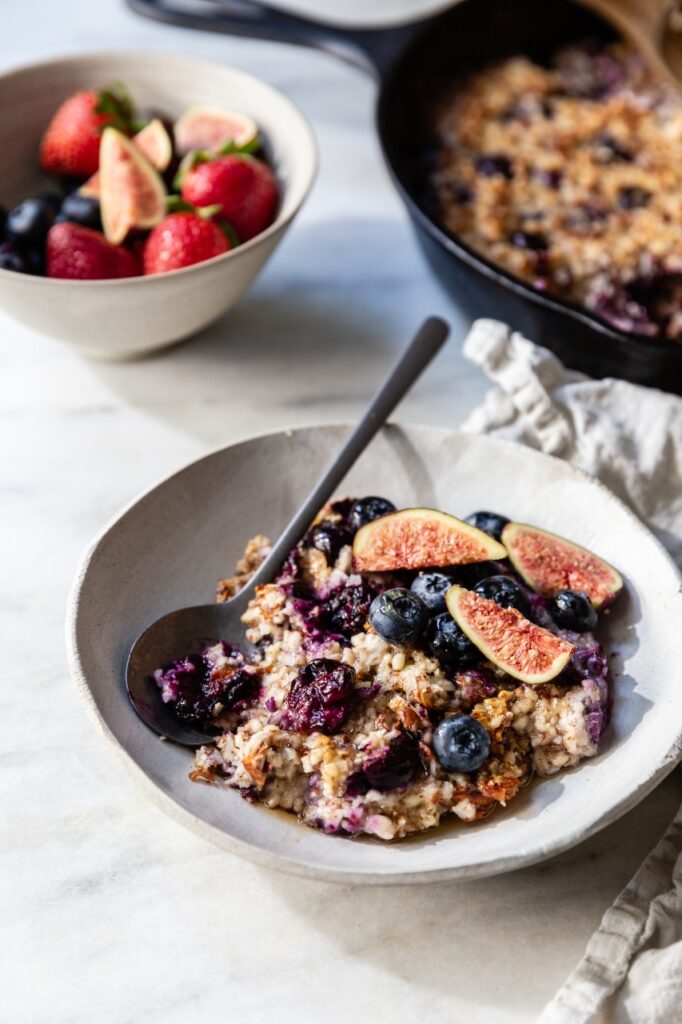 close up of paleo oatmeal with figs and blueberries in a white bowl